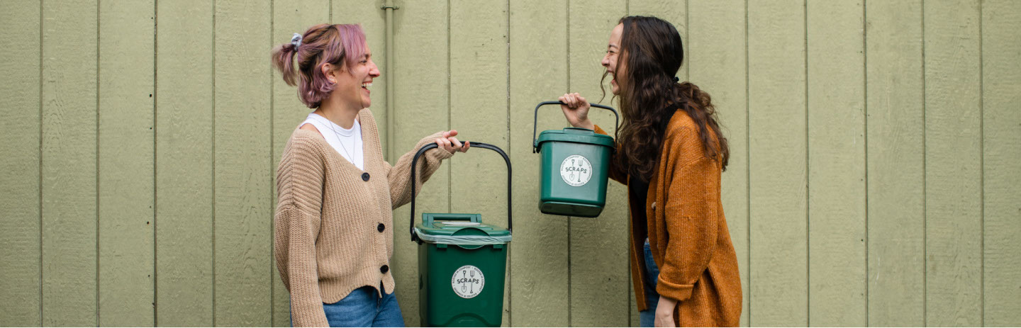 people talking while holding compost buckets